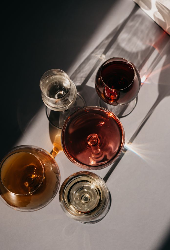 A sophisticated still life showcasing glasses of wine in a play of light and shadow.