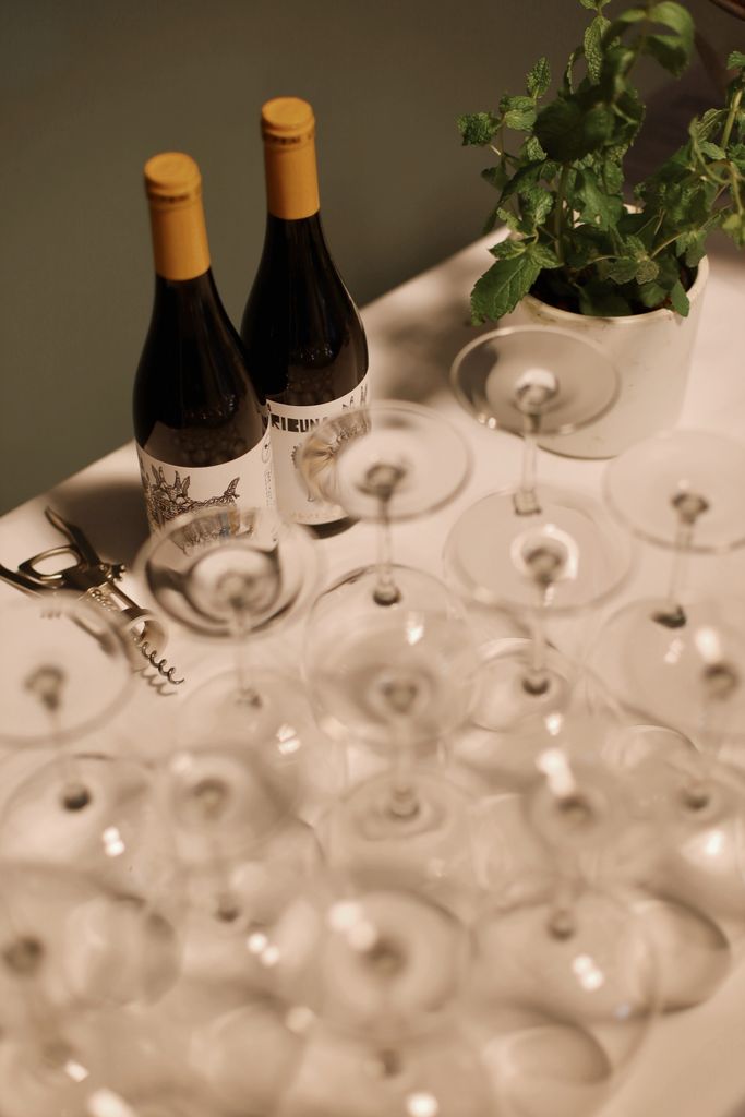 Two wine bottles surrounded by arranged glasses, offering a classy banquet vibe.